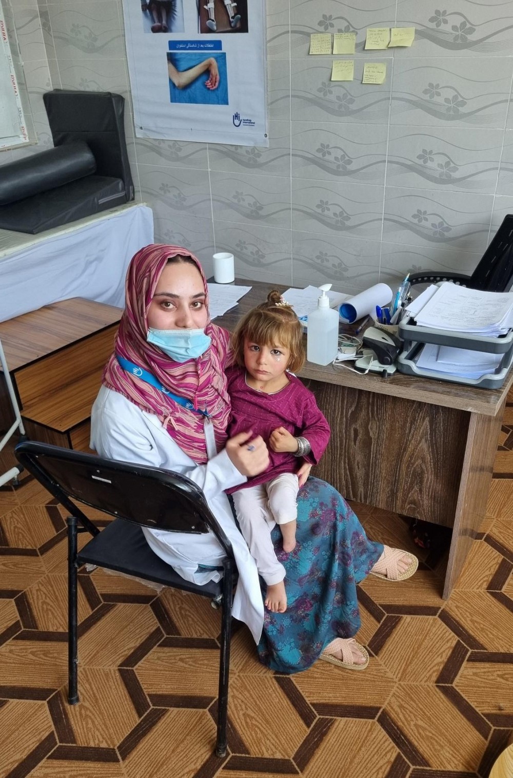 Small girl with the HI worker. She was born with a disability and is receiving psychotherapy while her mother receives caregiver education.